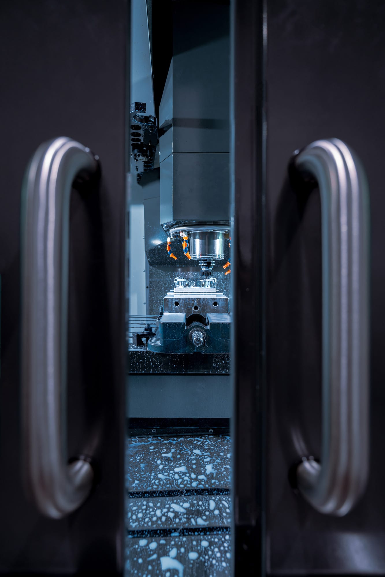 hybrid manufacturing cnc system inside of a hybrid cnc machine through the slightly open doors